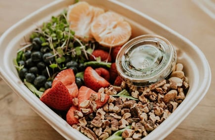 Healthy snack bowl with granola, fresh fruit, and greens