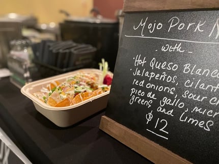 nachoss being served in a compostable fiber container