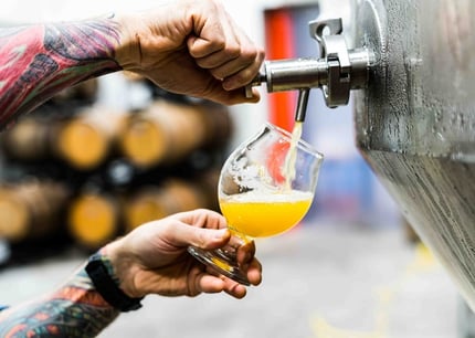 person pouring beer from craft beer handle