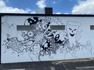 mural being painted on Nice Guys Pizza exterior