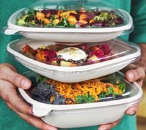stack of three fiber to-go boxes with food and lids