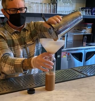 bartender mixing a to-go cocktail